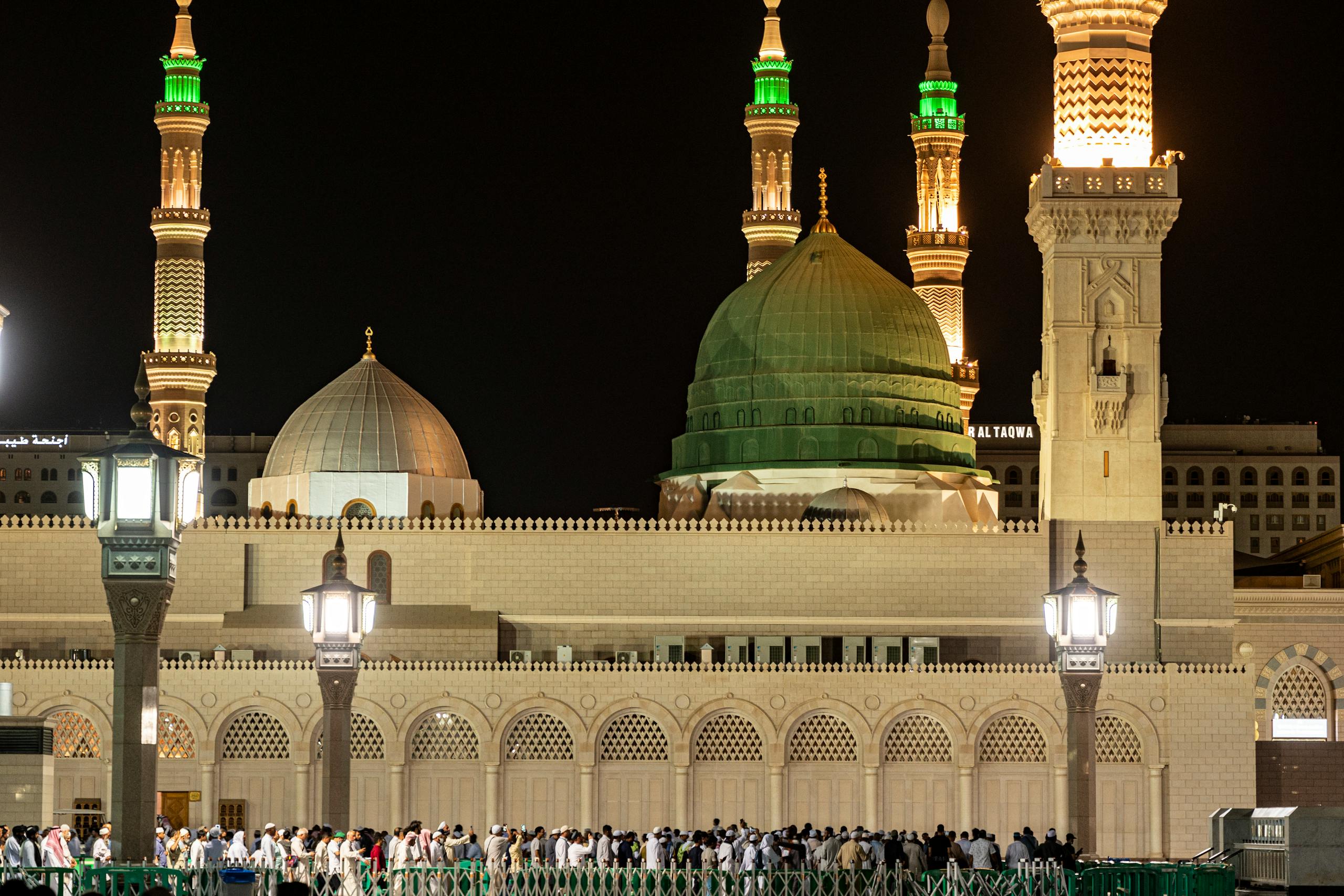 Captivating night view of Al-Masjid an-Nabawi, showcasing its illuminated domes and minarets in Medina, Saudi Arabia.