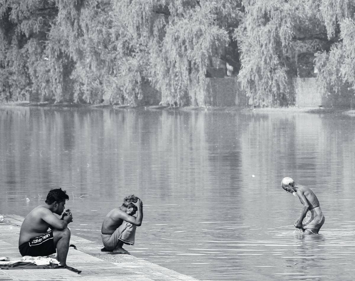 Capturing daily life activities by the lake in Dhaka, Bangladesh in a black and white photo.