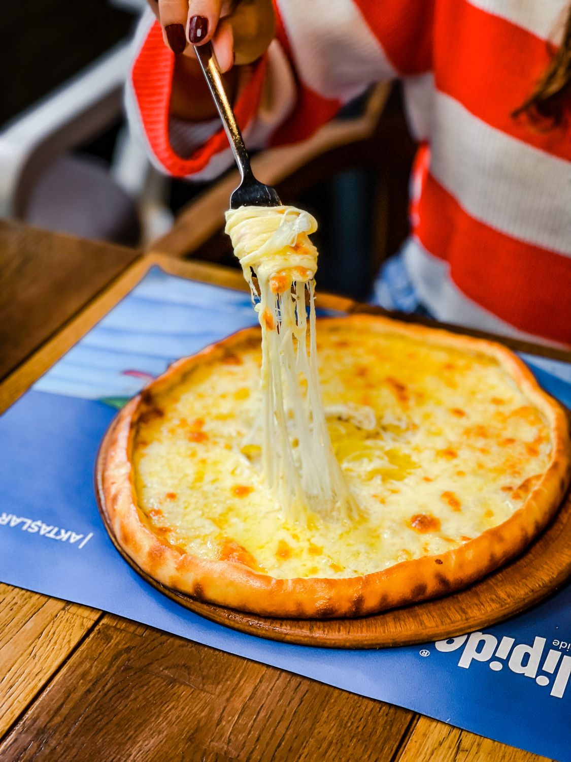 8 Reasons Burger Lovers Are Sleeping on This Southern Sandwich 2 Close-up of a cheesy pizza slice lifted with gooey melted cheese stretch indoors.