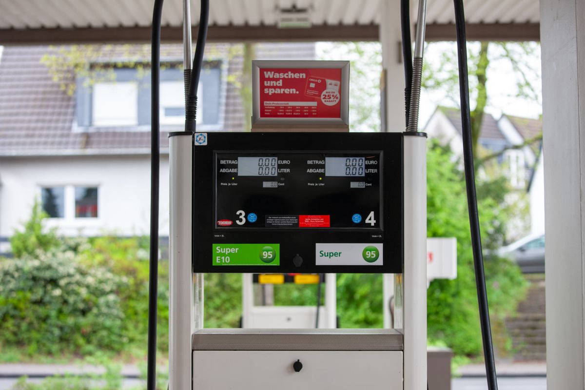 Relief at the Pump for Drivers as Oil Drops on U.S.–Iran Breakthrough Talks 1 Close-up of a gas pump at a station in Bergisch Gladbach, Germany, with surrounding houses visible.