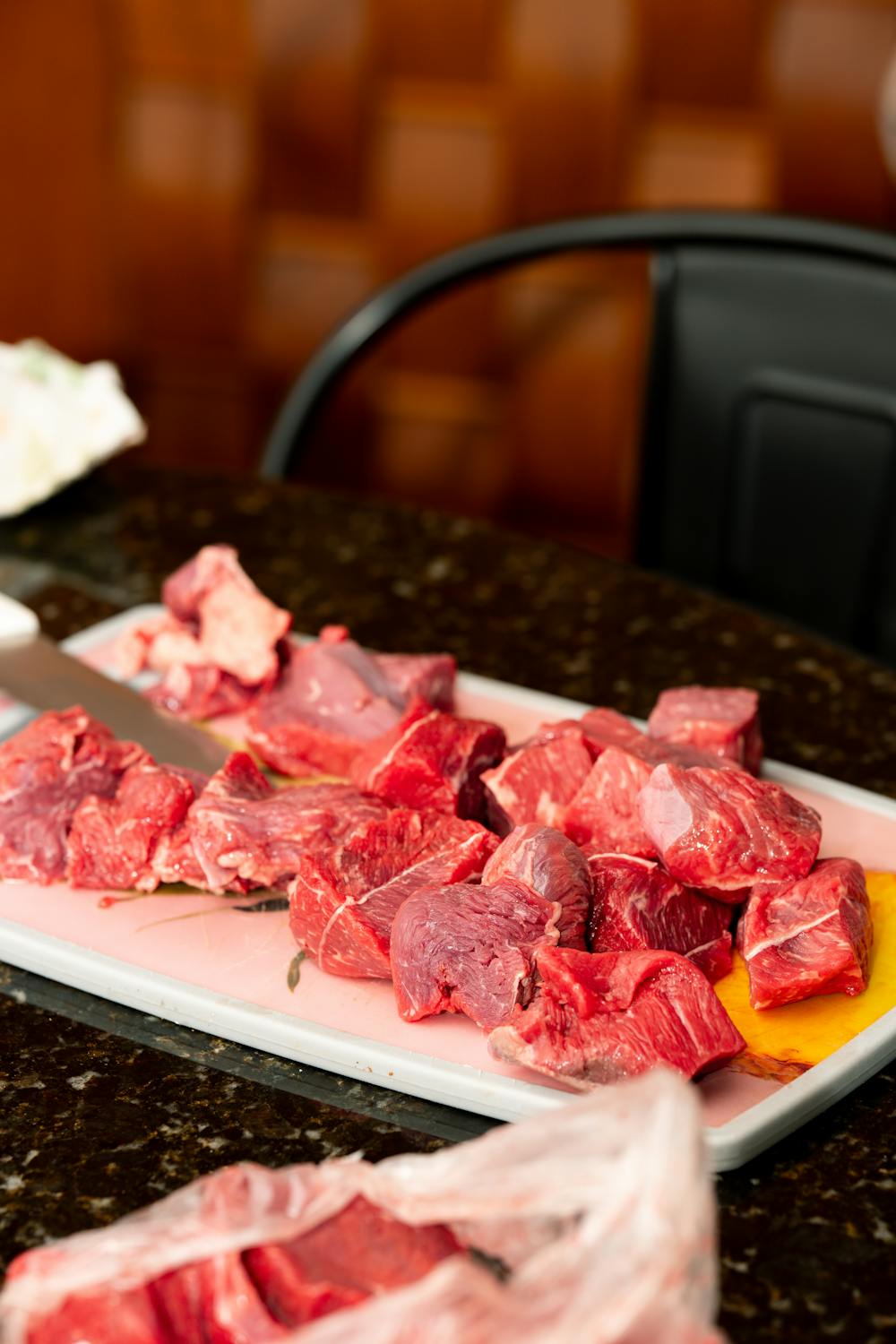 Close-up of raw beef chunks on a cutting board ready for cooking.