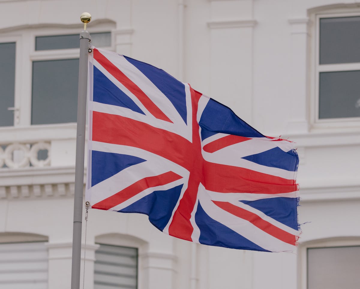12 Countries Where Men Are Losing Their Hair the Fastest 2 Close-up of the Union flag waving in front of a building in an urban area.