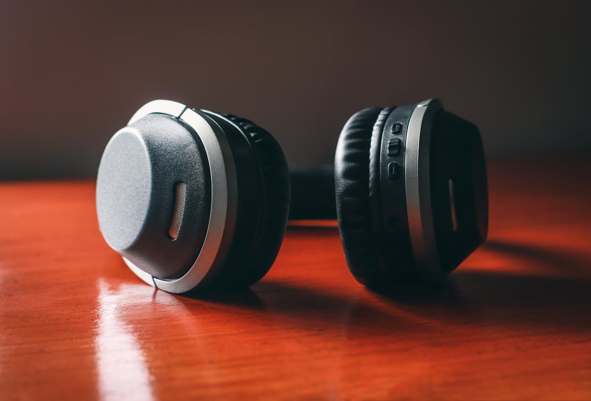 Brutally Relatable Things That Take Over ADHD Homes 4 Close-up of wireless headphones on a wooden table, emphasizing design and technology.