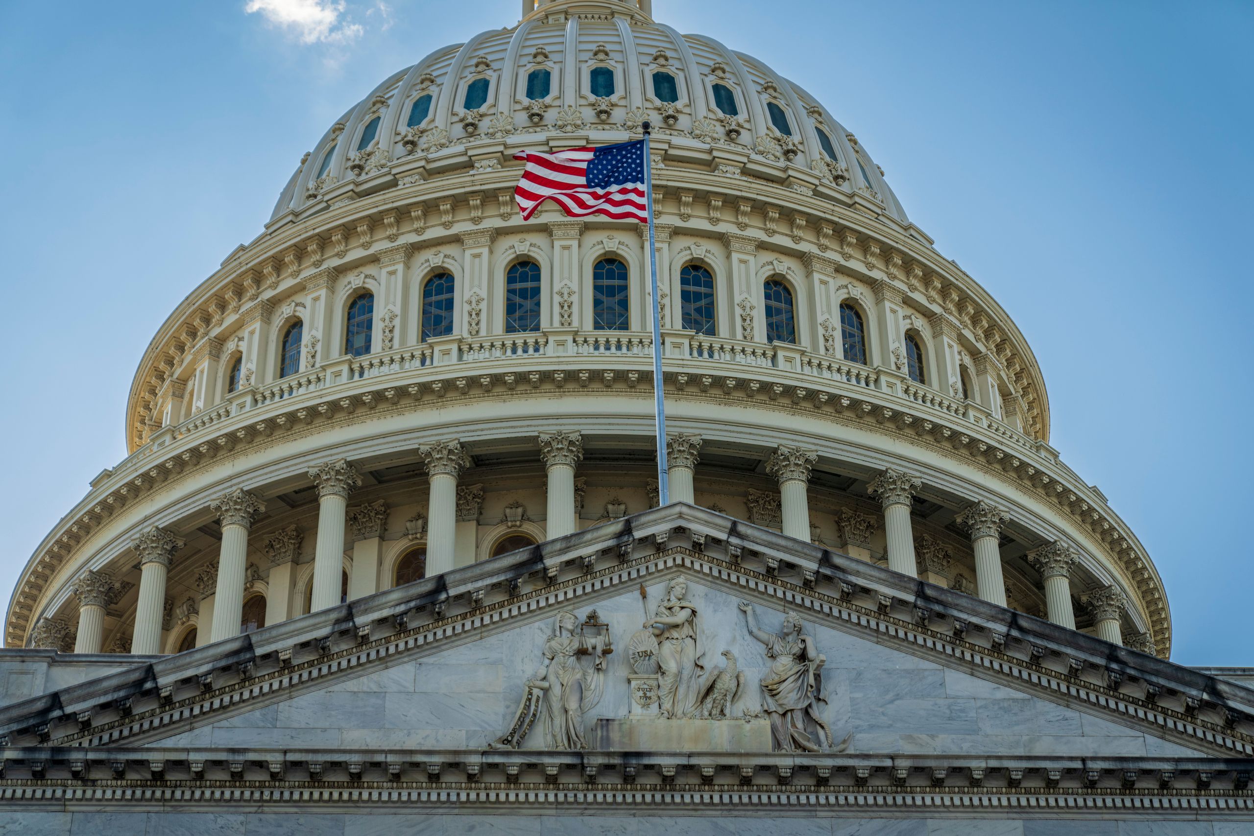 Close-up view of the iconic United States Capitol dome with American flag in Washington, D.C.