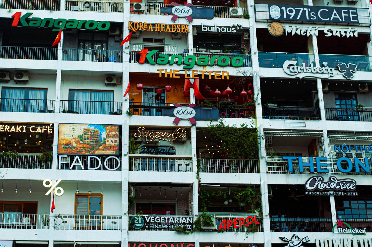America’s Most Iconic Restaurants Are Disappearing Fast, and the Numbers Show Why 2026 Could Be the Breaking Point 1 Colorful cafe and restaurant signs on a multi-story urban building facade, creating a vibrant city atmosphere.