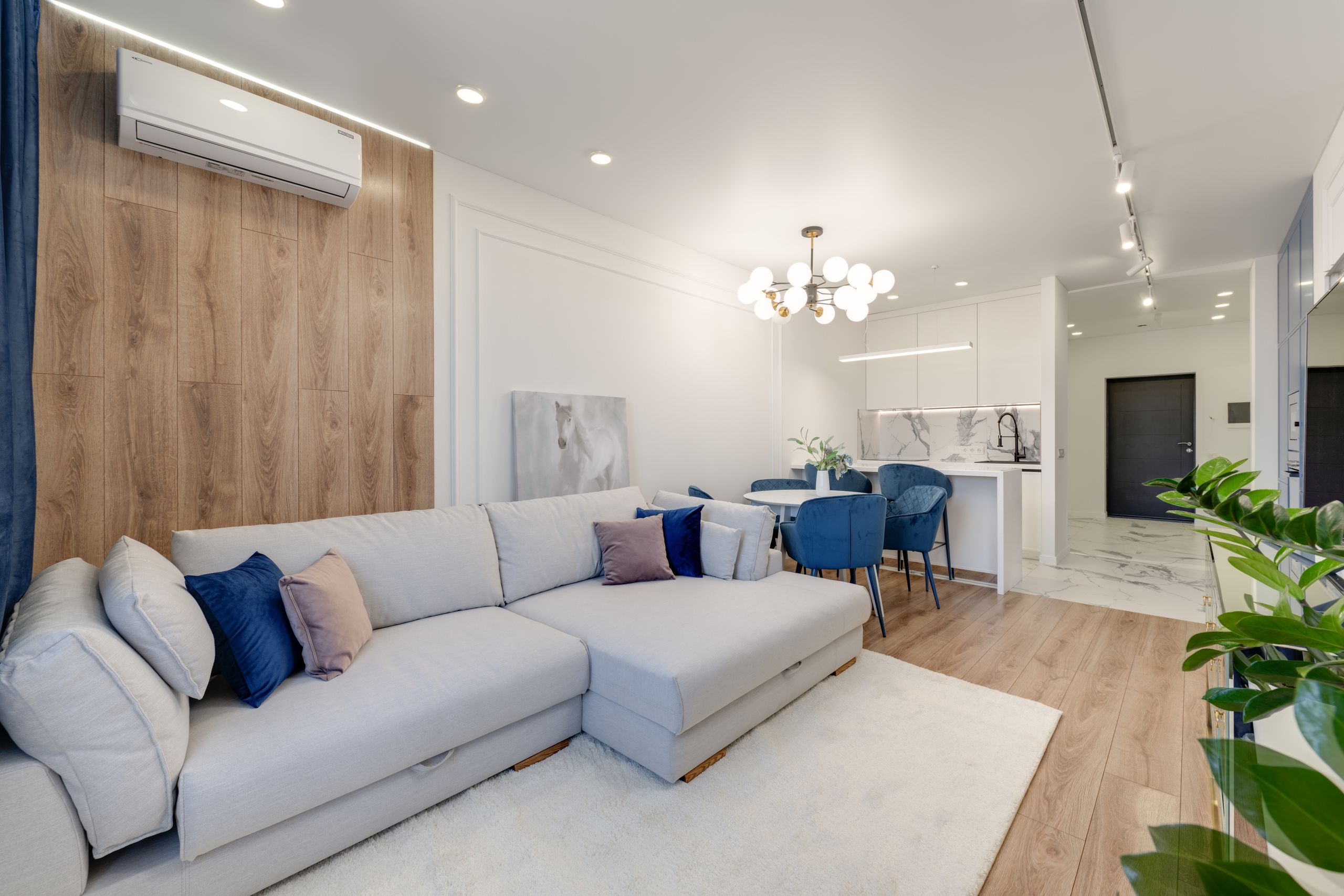 Arizona’s Summer Electricity Shock Is Back, and This Time It Feels Personal as Air Conditioning Becomes a Daily Financial Struggle 1 Contemporary living room with stylish furniture, elegant chandelier, and open kitchenette.