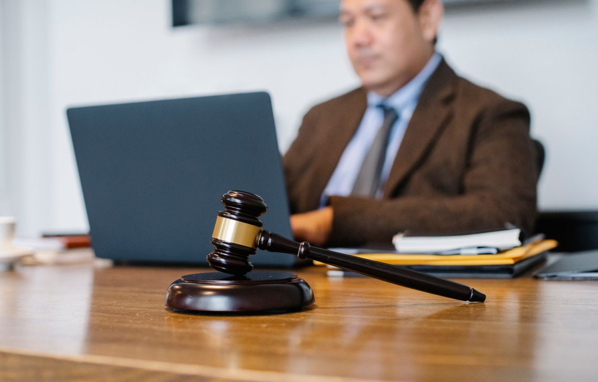 Grandmother Killed Inside Texas Home as Tesla Lawsuit Puts Full Self-Driving on Trial 2 Crop concentrated Asian male judge in formal clothes sitting using modern netbook while working in law office