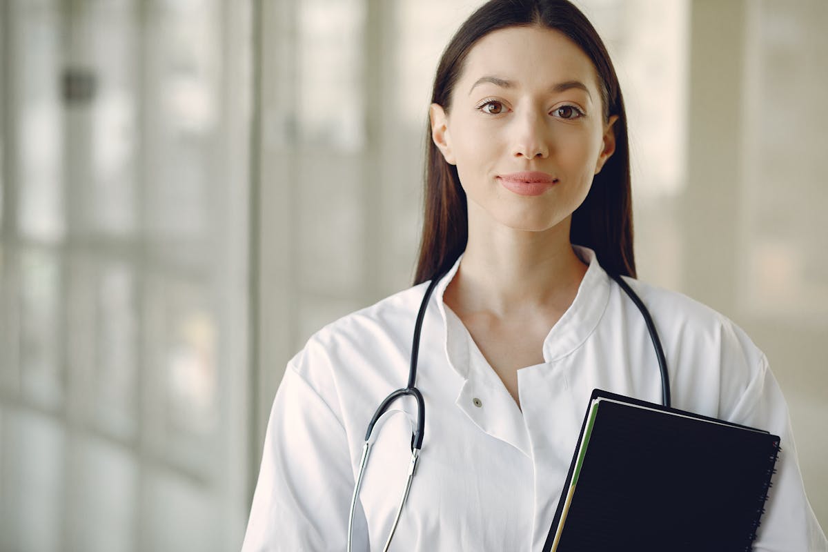 10 Things Retirees Miss About Working That Make Retirement Feel Strangely Empty 4 Crop smiling young ethnic female doctor in medical uniform with stethoscope and notebook standing in modern medical room with panoramic window