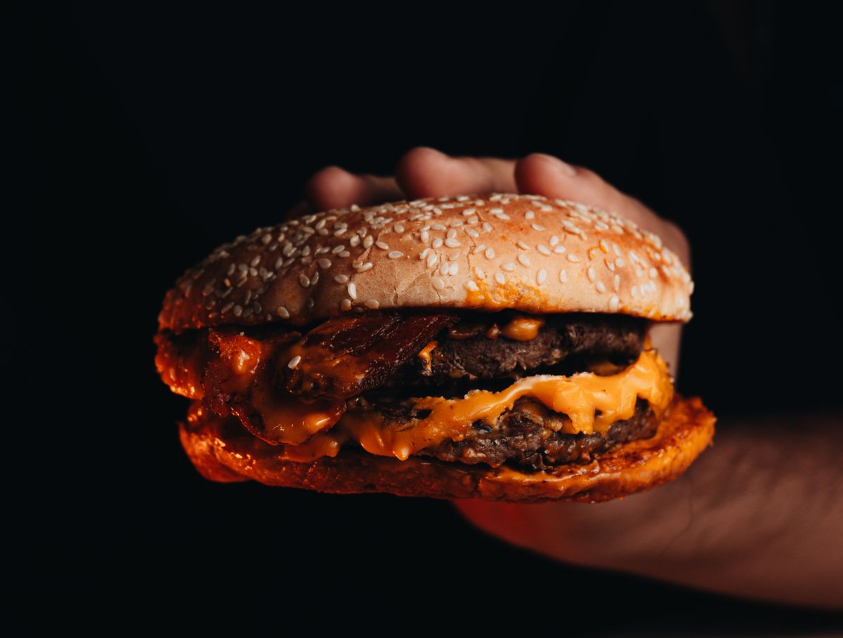 America’s Best Burger Chain Ranking Shows Why In-N-Out Beats McDonald’s, Burger King, and Wendy’s 3 Delicious cheeseburger held in hand with melted cheese and sesame bun.