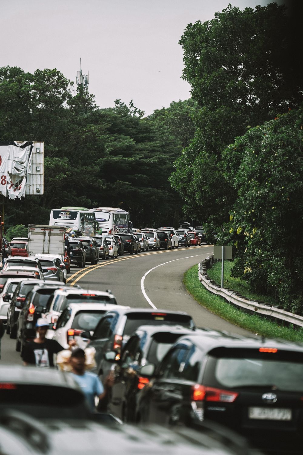 DuPage County Transportation System Under Pressure: Roads, Trails, and Daily Mobility Challenges Across the Region 2 Dense traffic jam on a winding road surrounded by lush greenery in West Java, Indonesia.