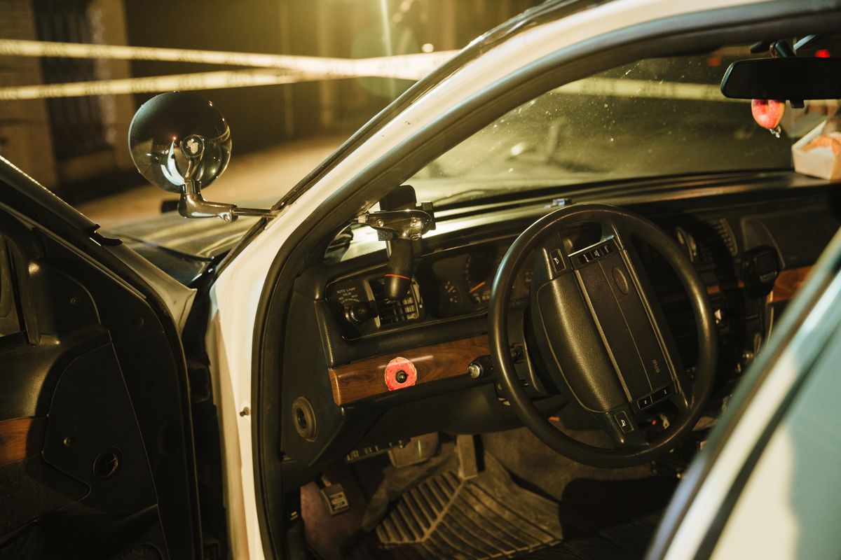 Detailed view of a police car interior with the driver’s door open at night.