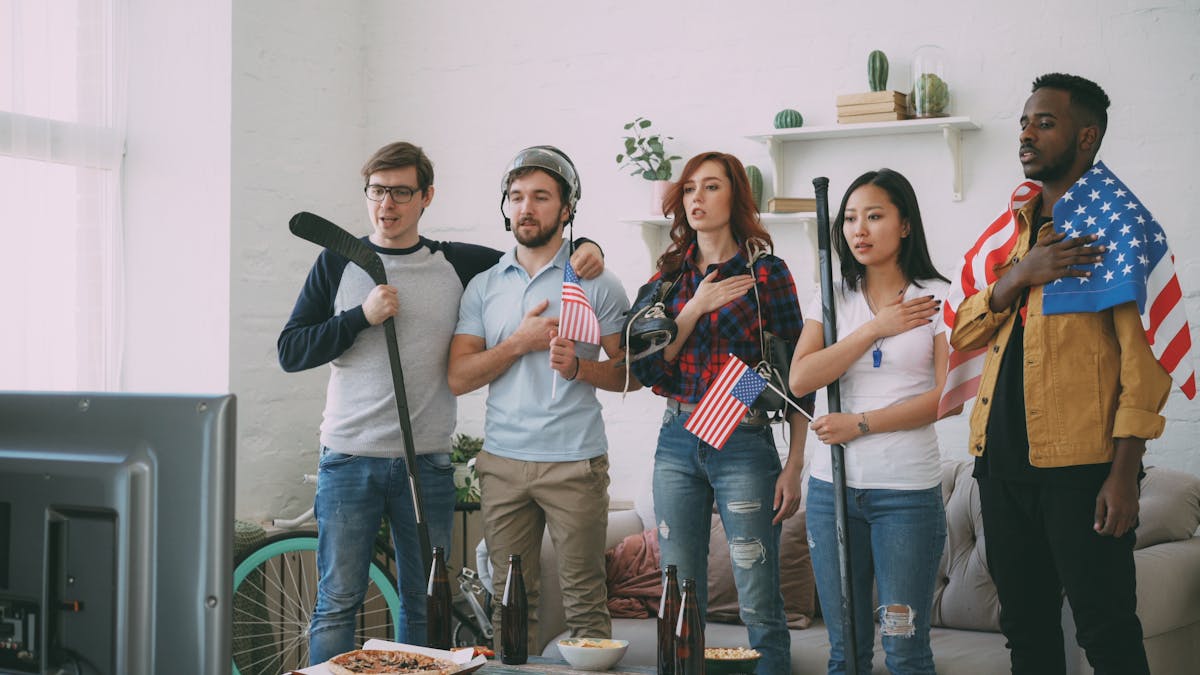 8 Ways the World Is Fed Up With Americans in 2026: A Global Backlash 2 Diverse group of friends watching sports on TV, shown with American flags indoors.