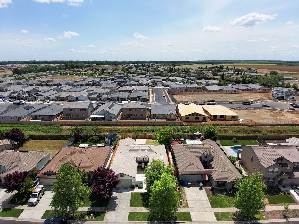 Trump’s Proof-of-Citizenship Voting Rule Hits a Wall as Judge Blocks Election Order 4 Drone view of suburban neighborhood with new housing developments and green surroundings.