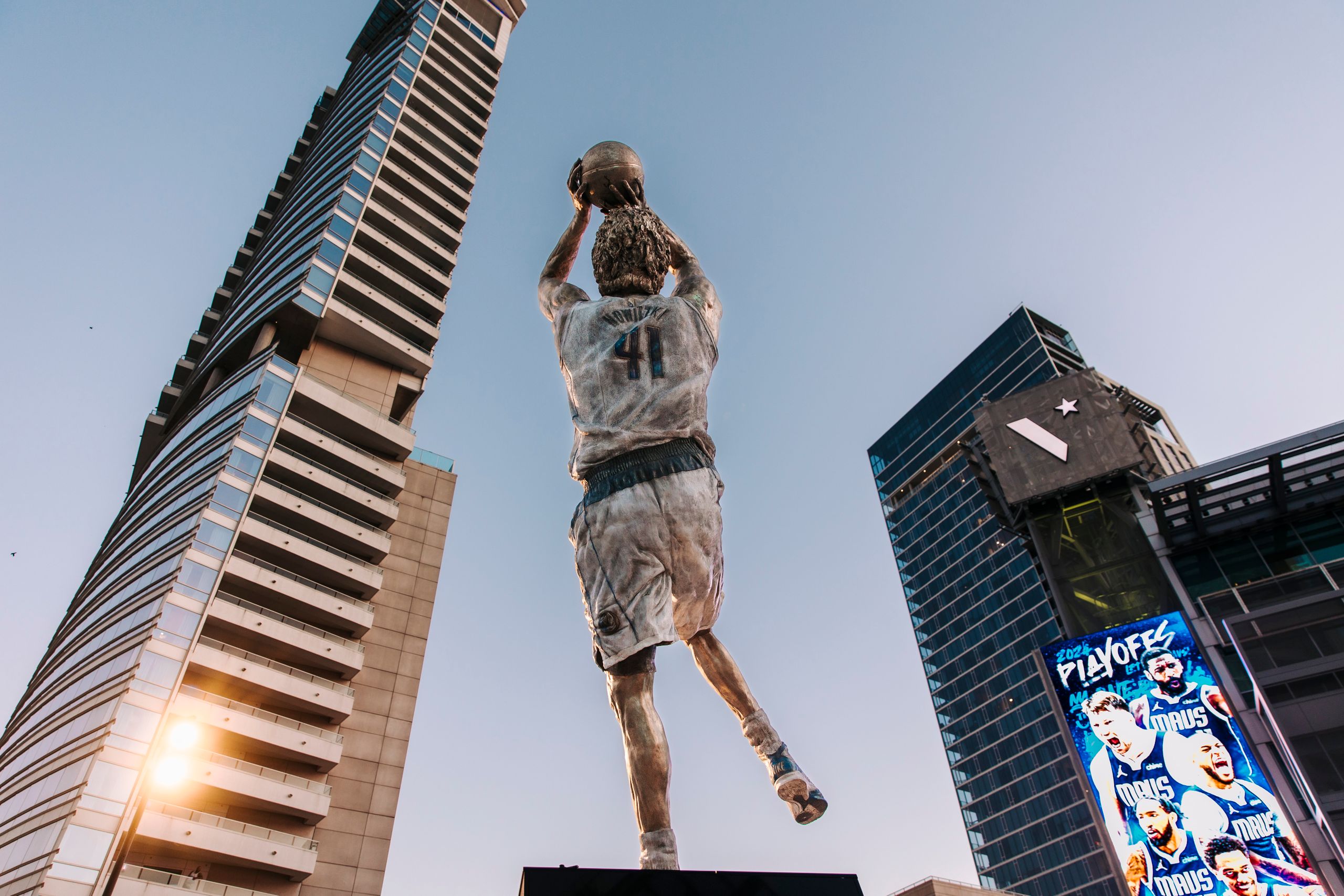 Jalen Brunson Left $113 Million Behind. Now Other NBA Stars May Feel the Pressure 2 Dynamic statue with basketball skyscraper backdrop showcasing urban architecture.
