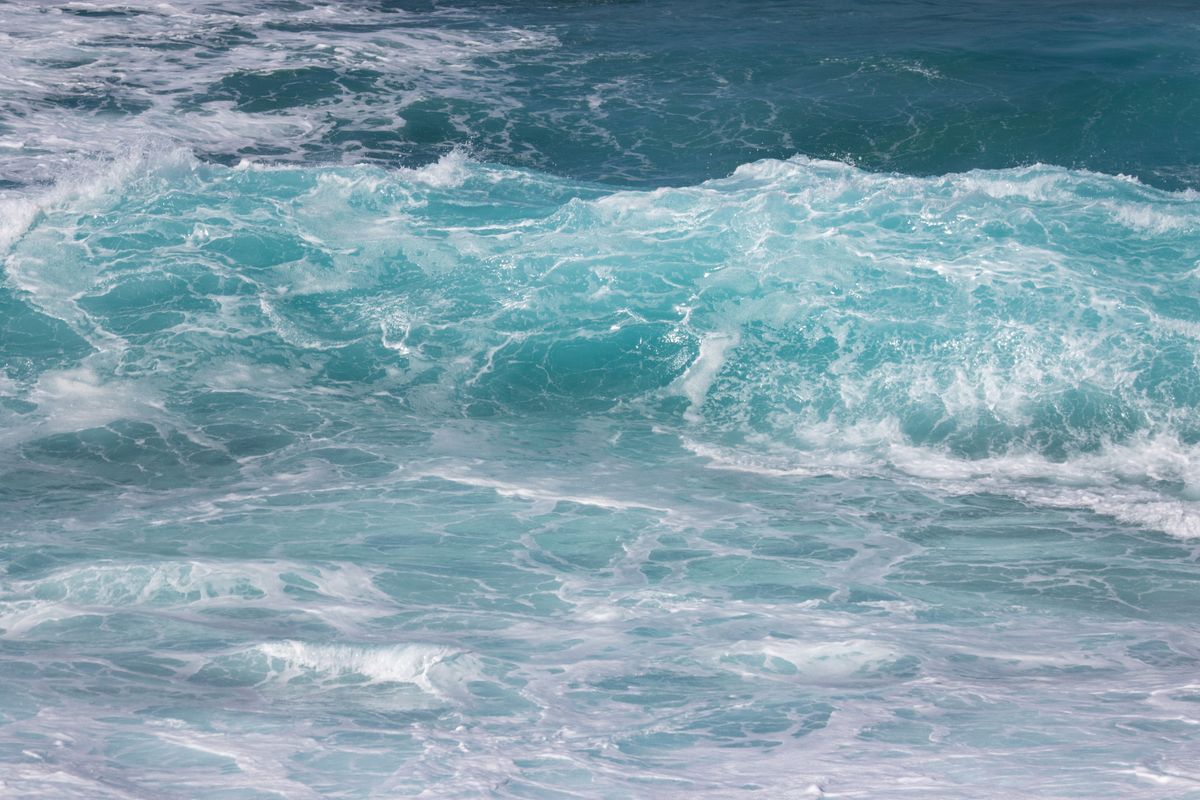 Dynamic waves crashing in the turquoise ocean, showcasing nature's powerful beauty.
