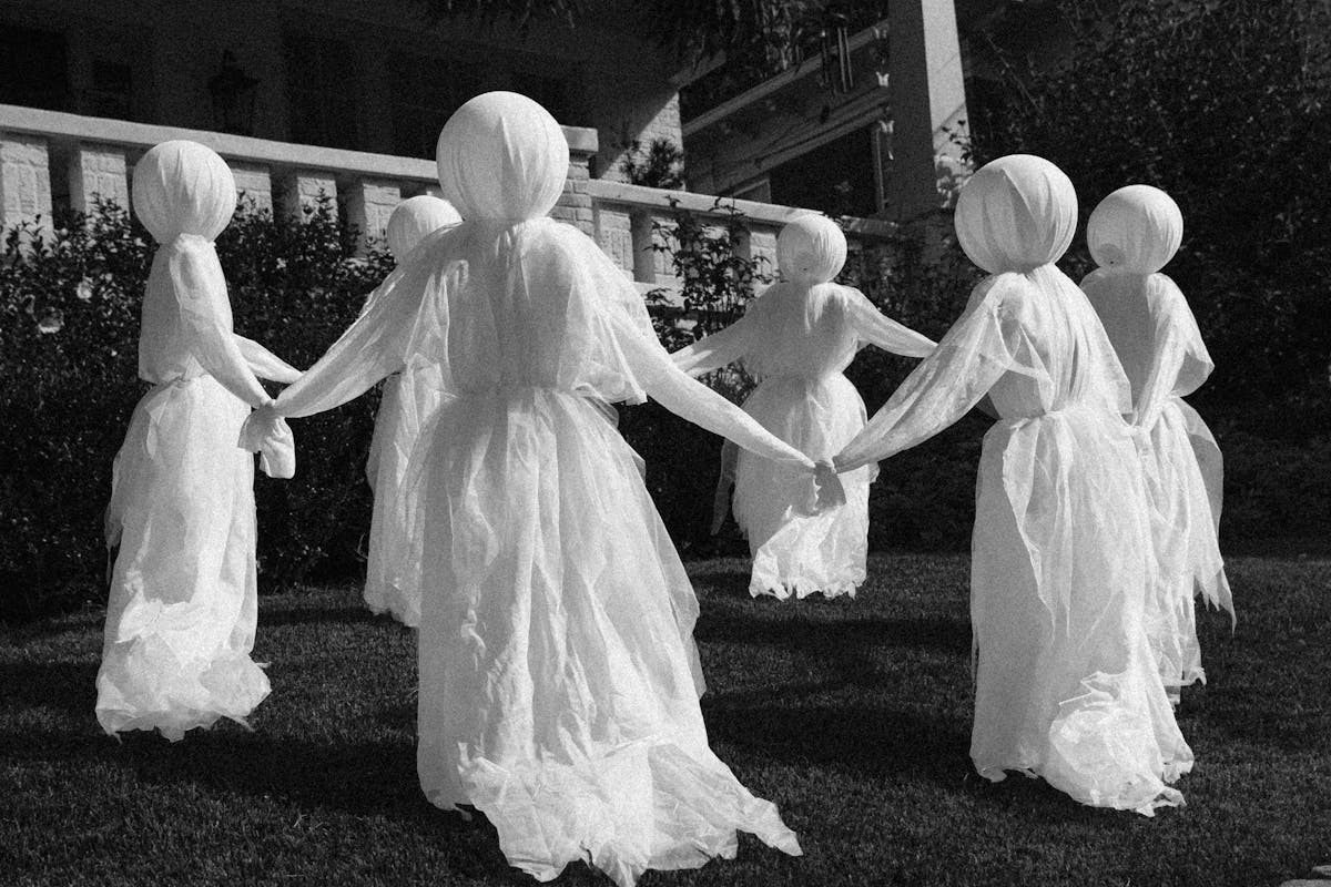The Frightening Truth Behind Why Some People ‘See’ Ghosts 1 Eerie ghostly figures in white cloth arranged in a circle, creating a haunting scene.
