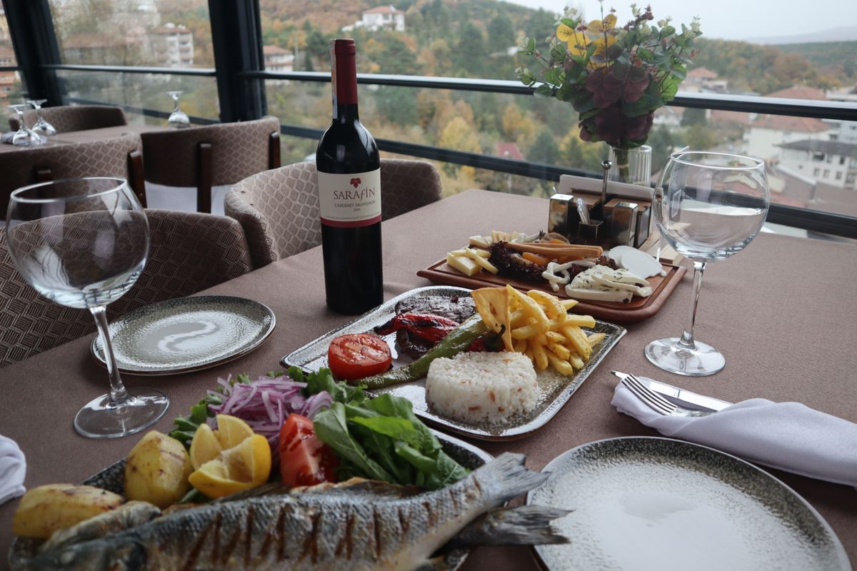 Chicago Welcomes Muhājir on July 1st as New Food Concept Redefines Global Dining 1 Elegantly set table with wine and gourmet dishes, offering a picturesque view of the landscape.