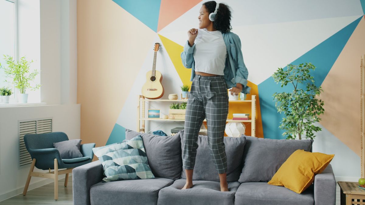 10 Horrific Things That Can Ruin Your Morning Before It Even Starts 2 Energetic woman enjoying music, dancing joyfully on a comfortable couch.
