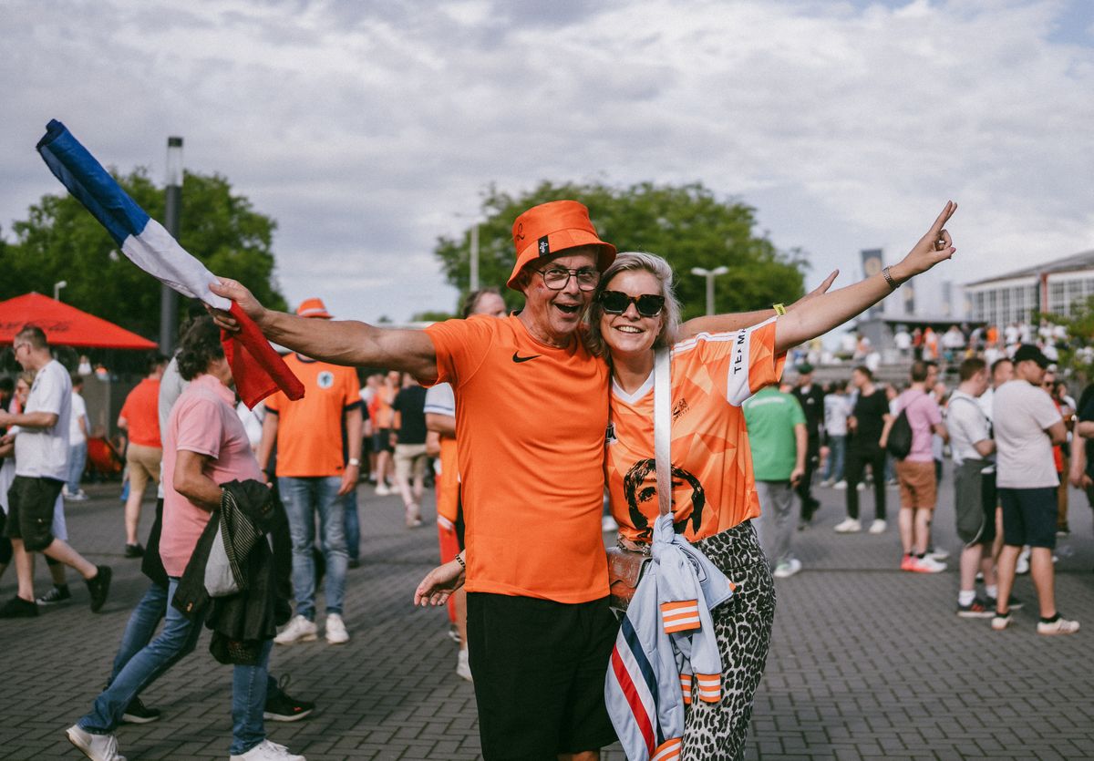 Argentina Fans Bring a Beef Debate to Texas As World Cup Fever Turns Dallas Into An Asado vs. Barbecue Battleground 1 Enthusiastic fans in orange outfits celebrating together with flags at an outdoor event.