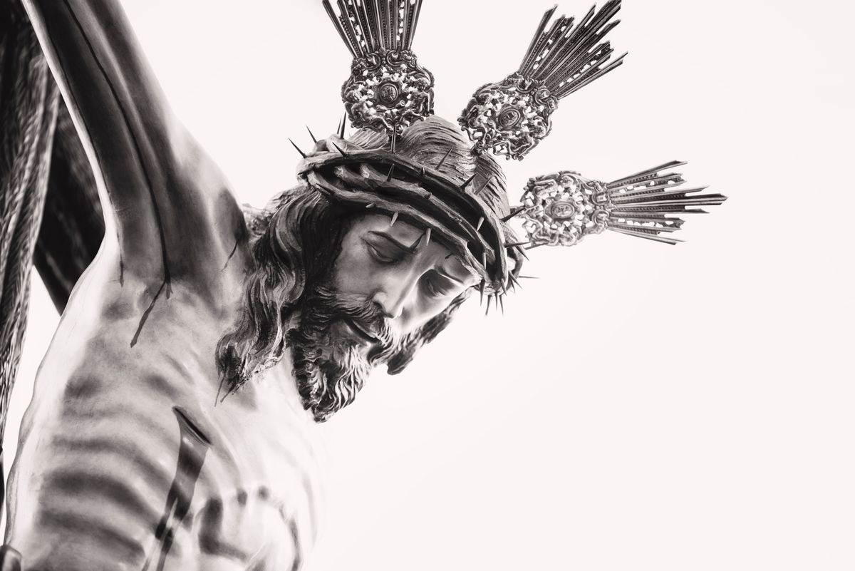 Fine art depiction of a crucifixion sculpture in black and white, highlighting religious symbolism.