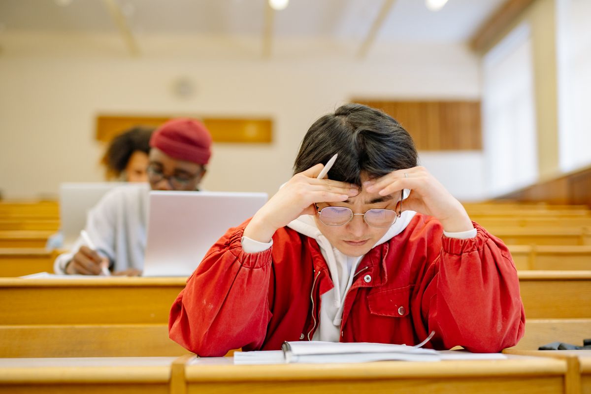 Focused students studying intensely in a university lecture hall setting.