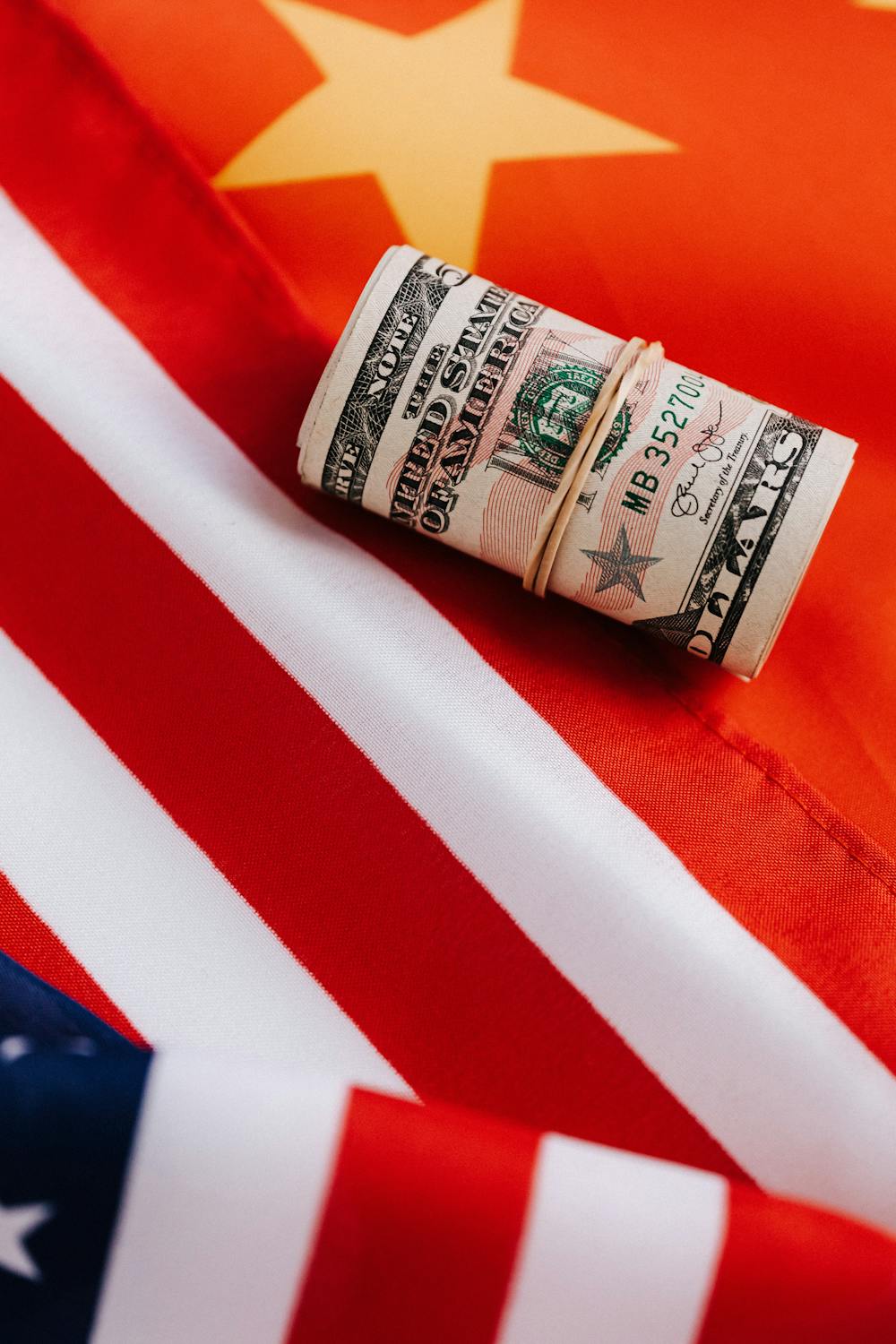10 Things Americans Should Know When a Country Runs Out of Money 1 From above of colorful flag of United Stated of America with stripes and star near roll of dollar banknotes tied with rubber band