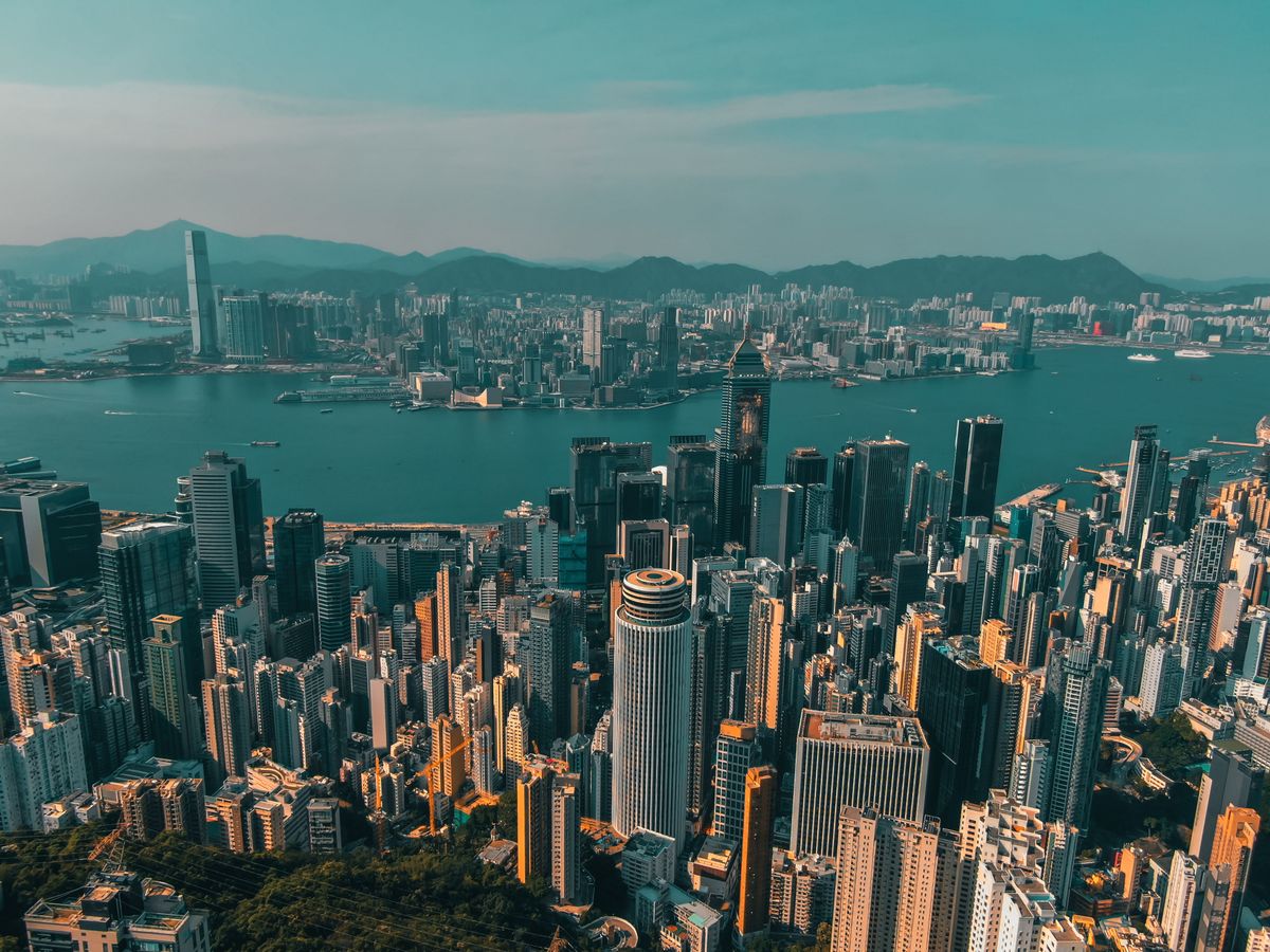 Hong Kong Leads Top Markets in Ultra-Rich Population Growth, Surpassing New York and Tokyo 1 From above of contemporary skyscrapers of modern megapolis located on shore of river against blue sky