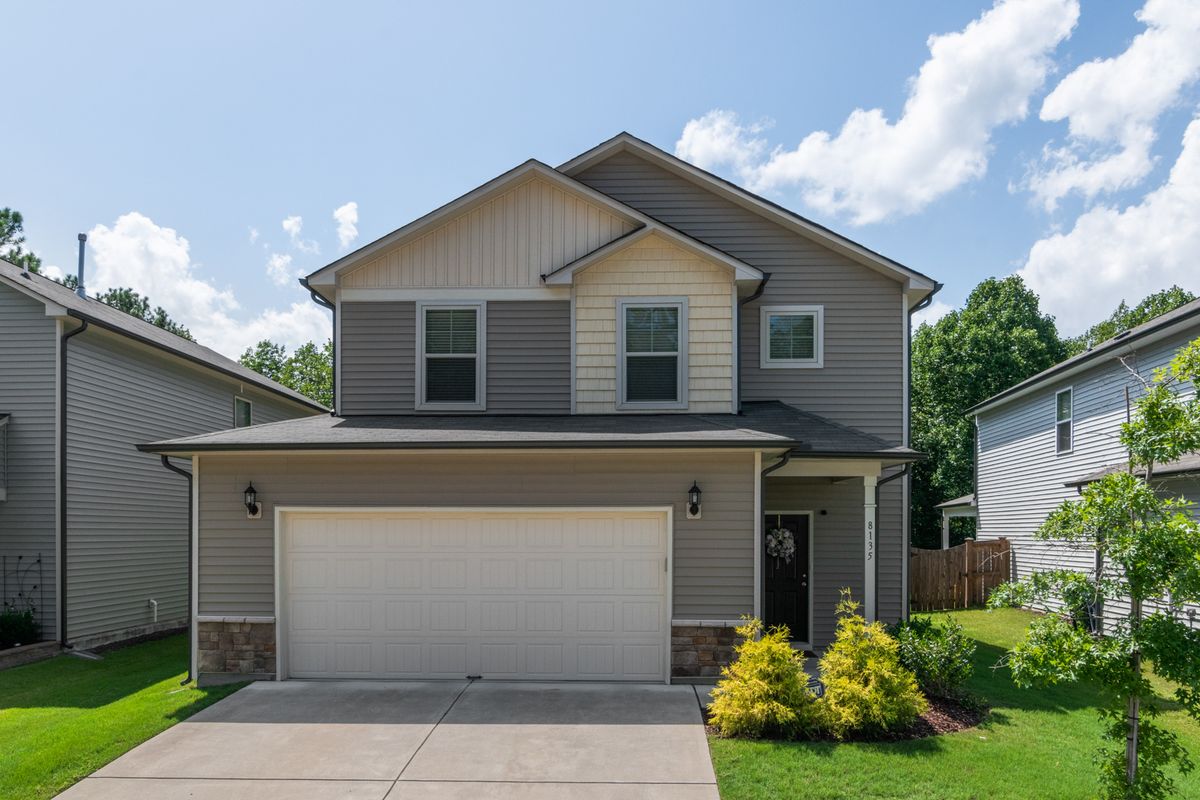 Front view of a modern suburban family home with lush landscaping.