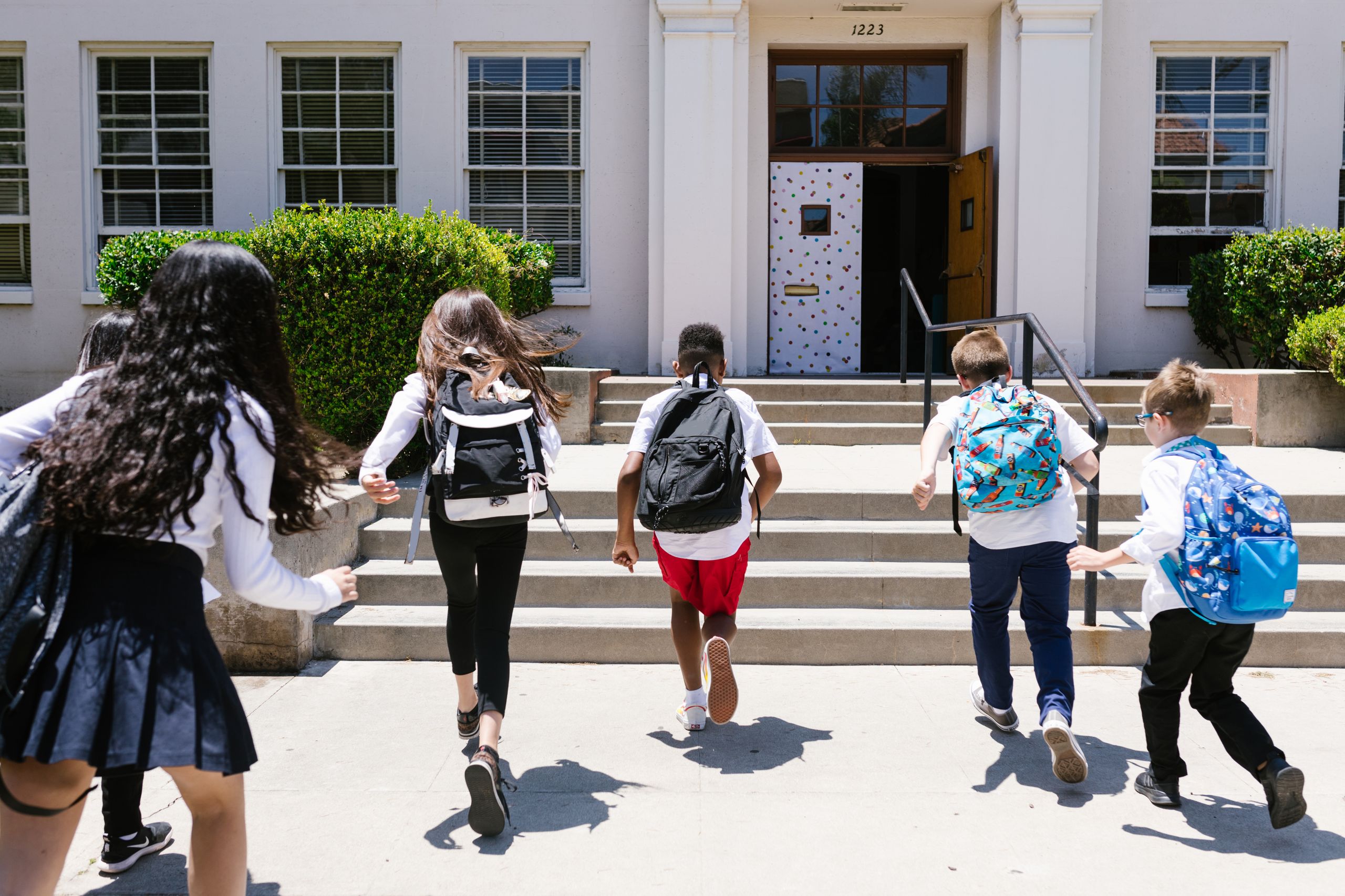Utah’s measles outbreak exposes the vaccine problem America keeps avoiding 2 Group of students with backpacks running into school, captured from behind, showing excitement.