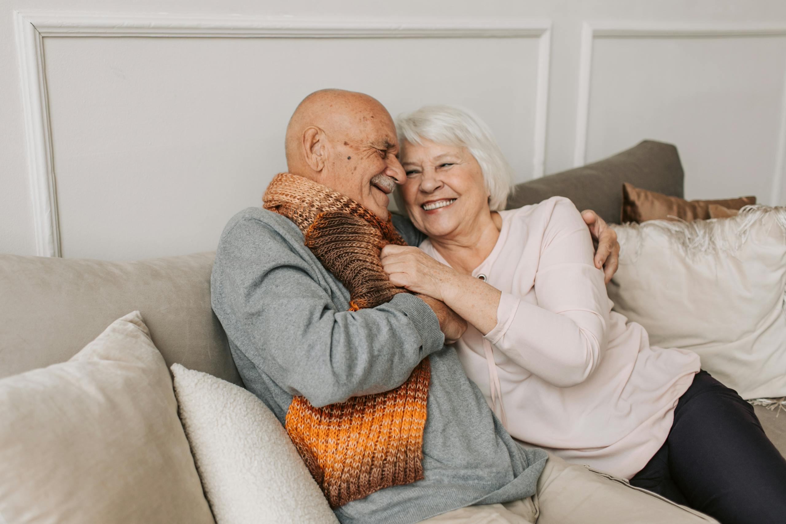 11 Harsh Truths About Marriage After 30 Years That Couples Quietly Learn 6 Happy elderly couple embraced in a cozy home setting, sharing joyful smiles.