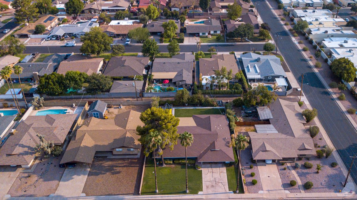 High-angle view of suburban houses and streets in a sunny neighborhood.