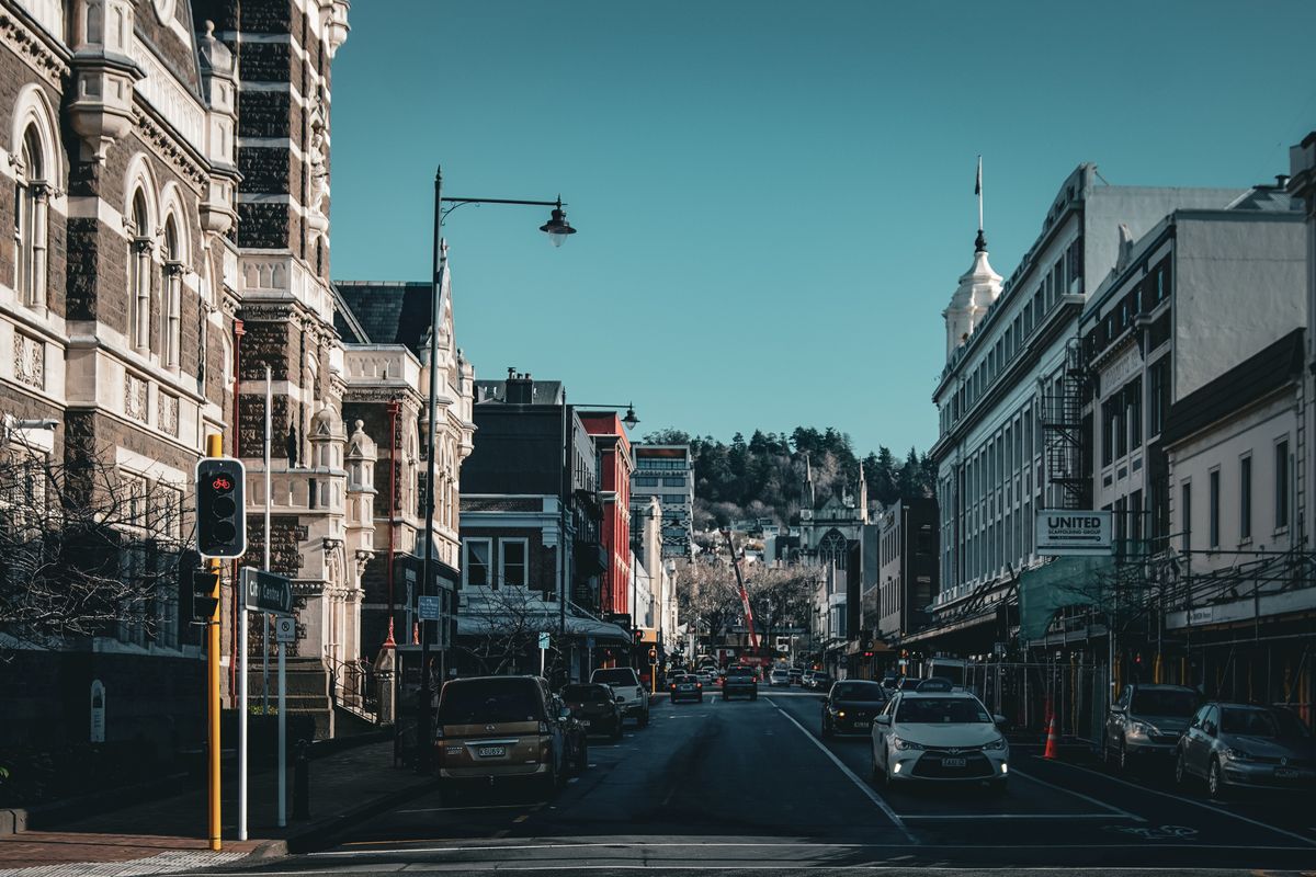 Everyone Wants to Move to Canada… But the Reality Is Not What You Expect 2 Historic urban street view in Dunedin with classic architecture and light traffic.