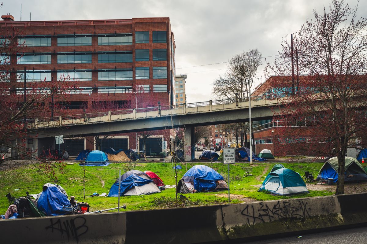 Homeless encampment with tents in downtown Portland under an overpass, capturing social issues.