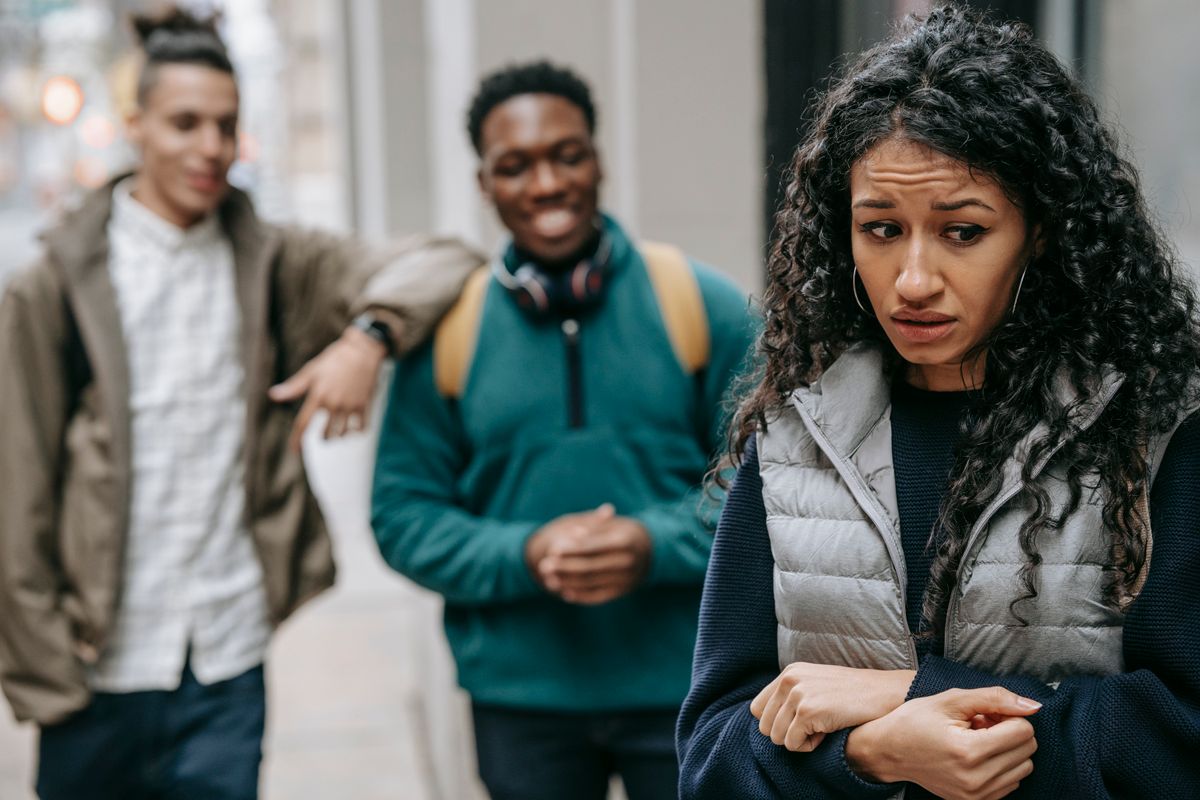 7 Ruthless Signs Someone Is Secretly Sabotaging Your Success 1 Laughing multiracial teenage boys mocking at depressed young ethnic female standing on street after school