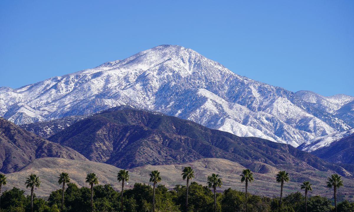 10 California Regions Where Wildfire Smoke Can Turn Dangerous Fast 3 Majestic snow-capped mountains with palm trees in Redlands, California, on a clear day.