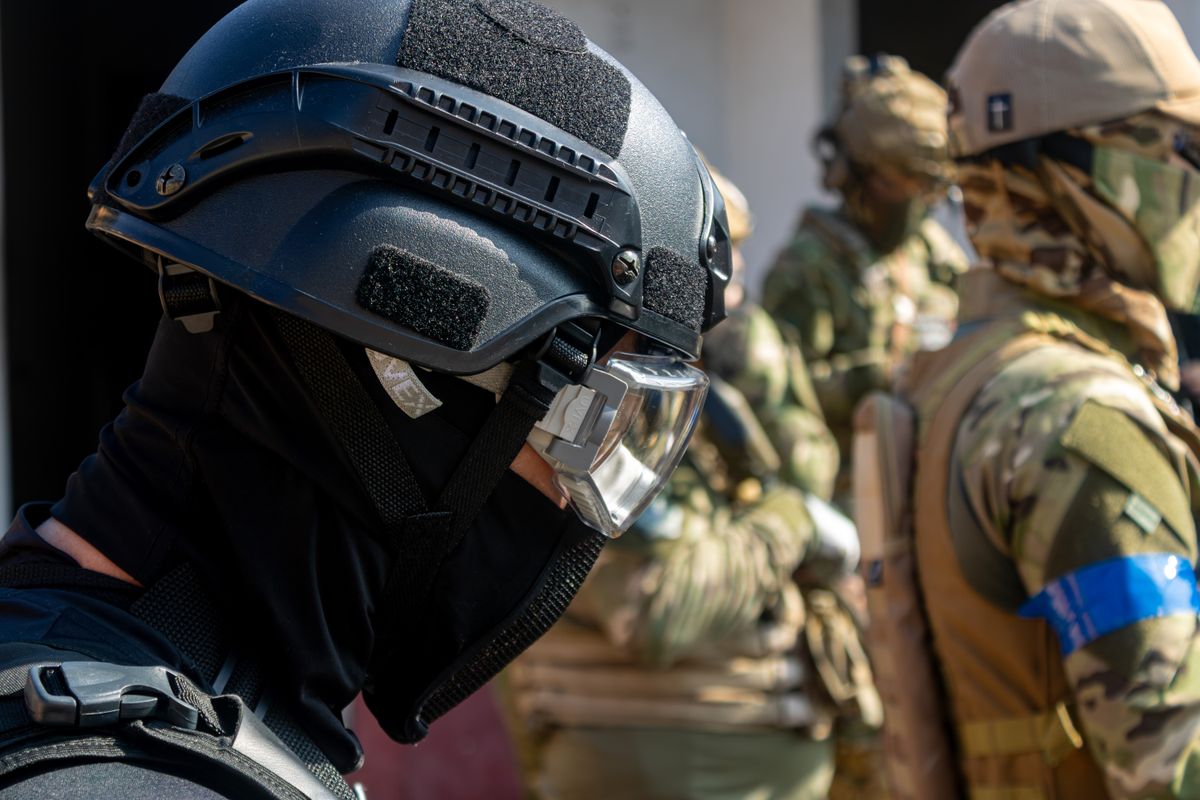 Military personnel in tactical gear during a training exercise, showcasing teamwork and readiness.