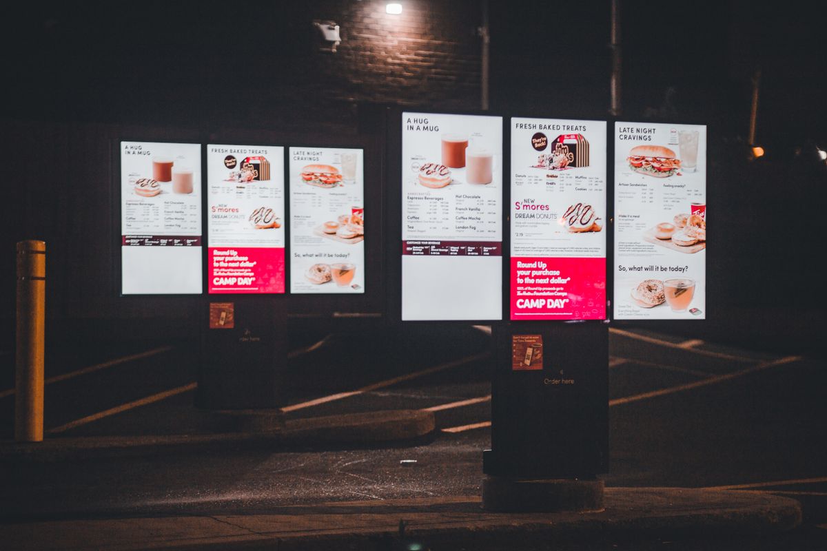 Chain Restaurant Prices in 2026 Have Crossed A Line, and These 4 Brands Show Why Americans Are Pushing Back 1 Nighttime view of an illuminated fast food drive-thru menu with digital display and clear copyspace.