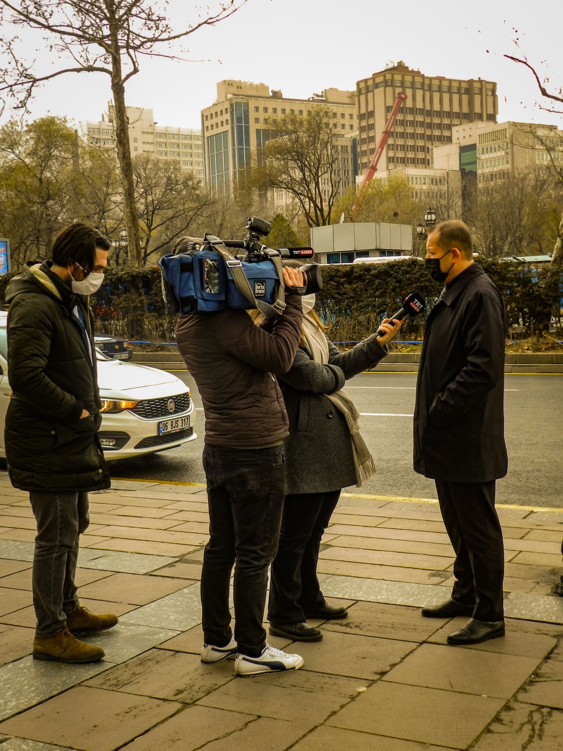 Outdoor street interview scene with journalists capturing a news event.