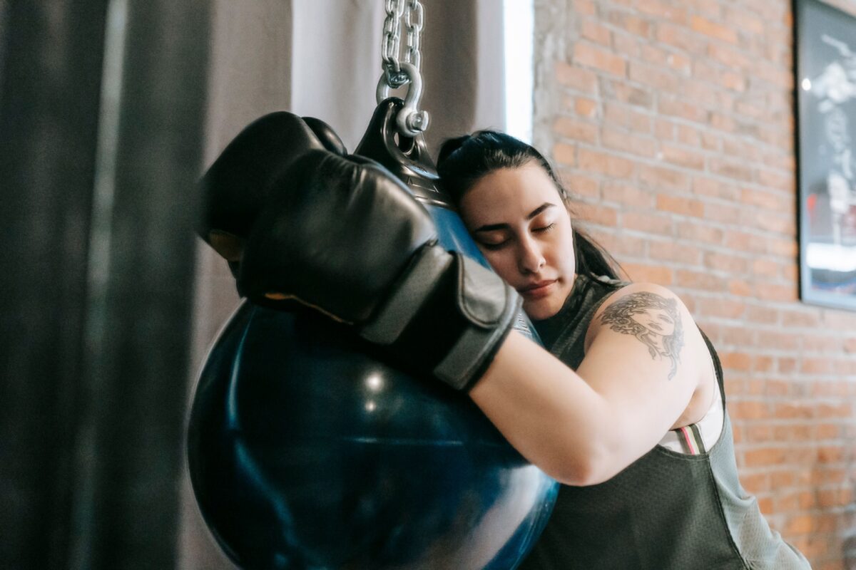 tired-woman-in-boxing-gloves-resting-after-training