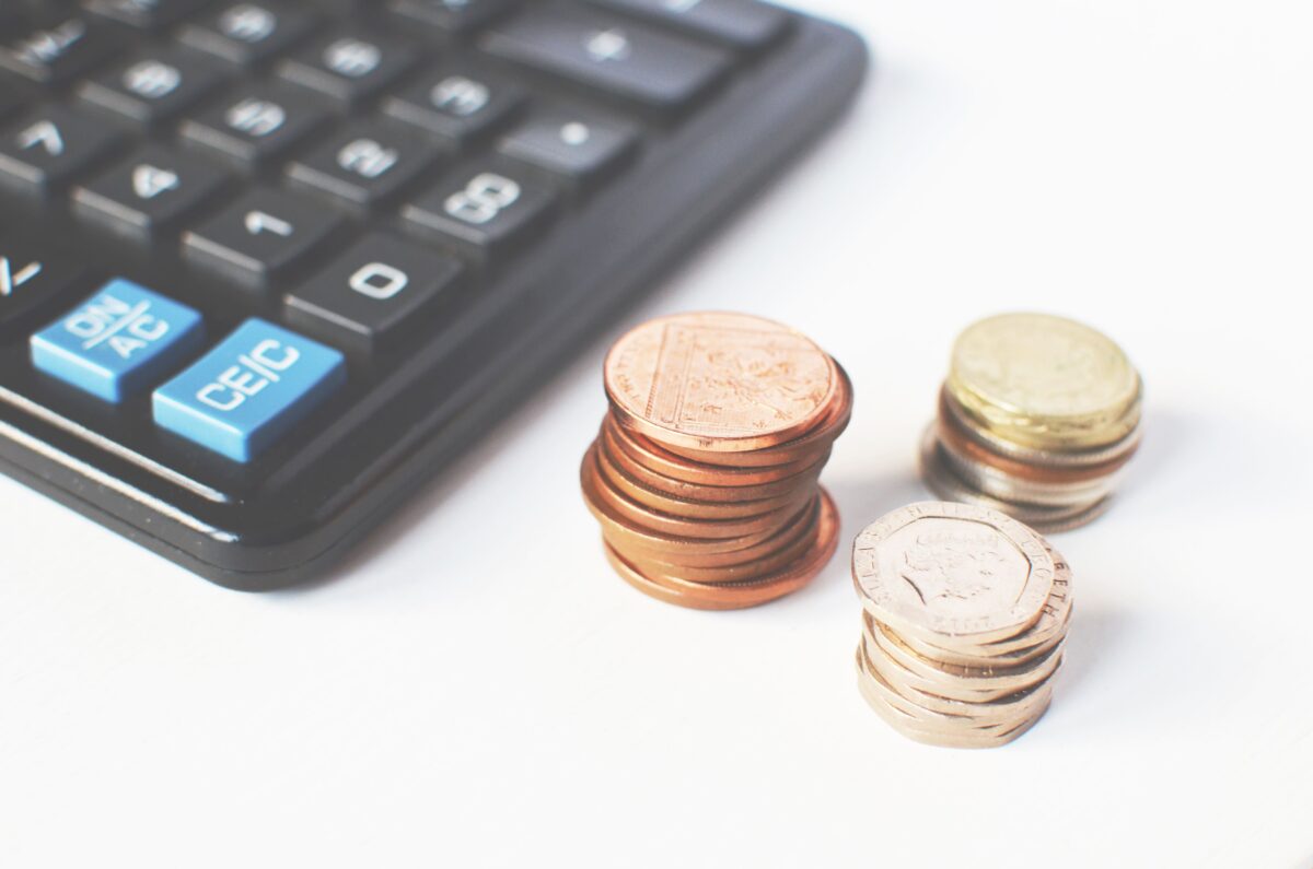 gold-colored-coins-near-calculator