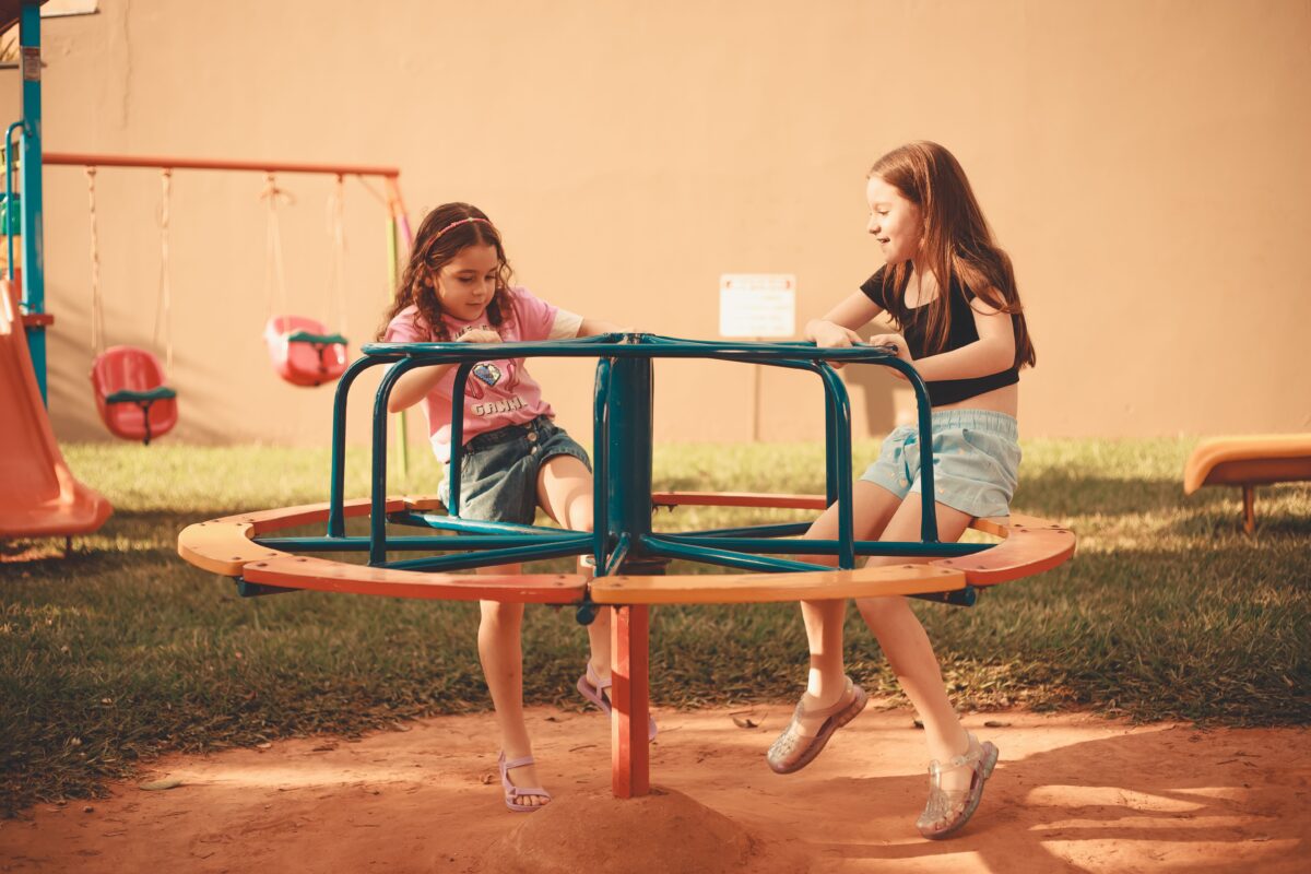 girl-sitting-together-on-carousel