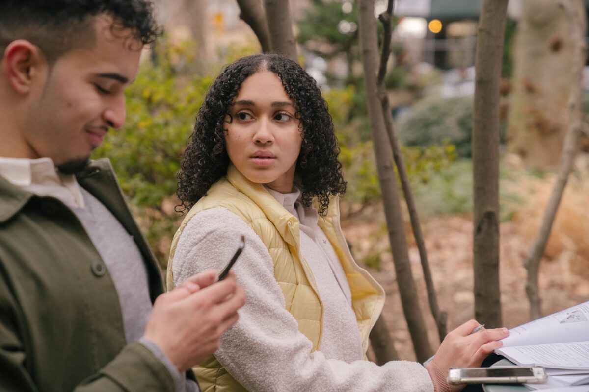 latin-american-couple-at-table-with-textbooks-with-smartphones