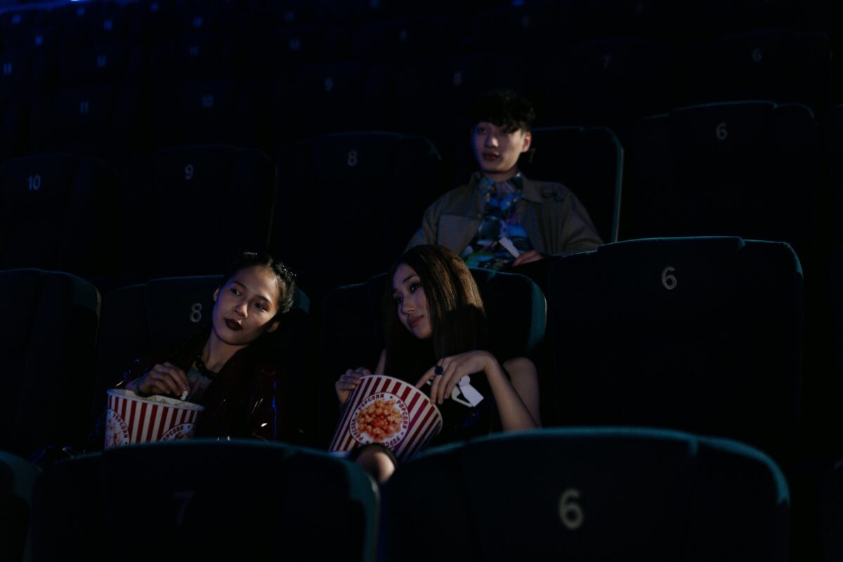 group-of-friends-sitting-on-a-cinema-while-seriously-watching-movie