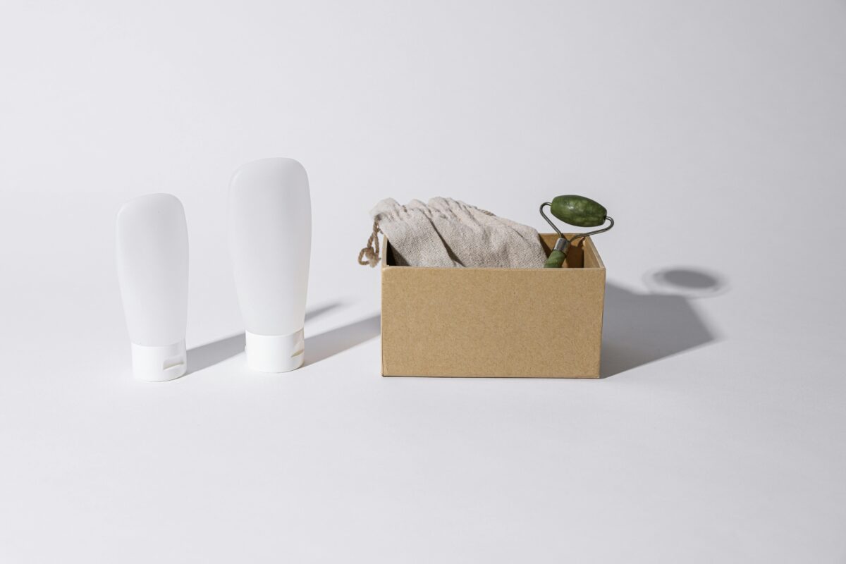 a-box-with-jade-roller-beside-white-plastic-tubes