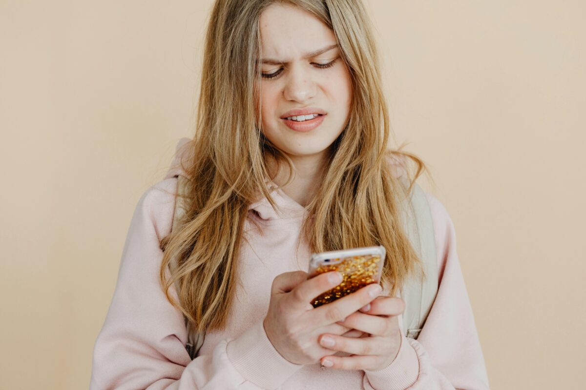 a-woman-in-pink-hoodie-using-her-phone
