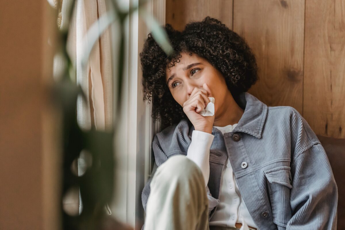 grief-young-black-woman-sitting-near-wooden-wall-and-crying