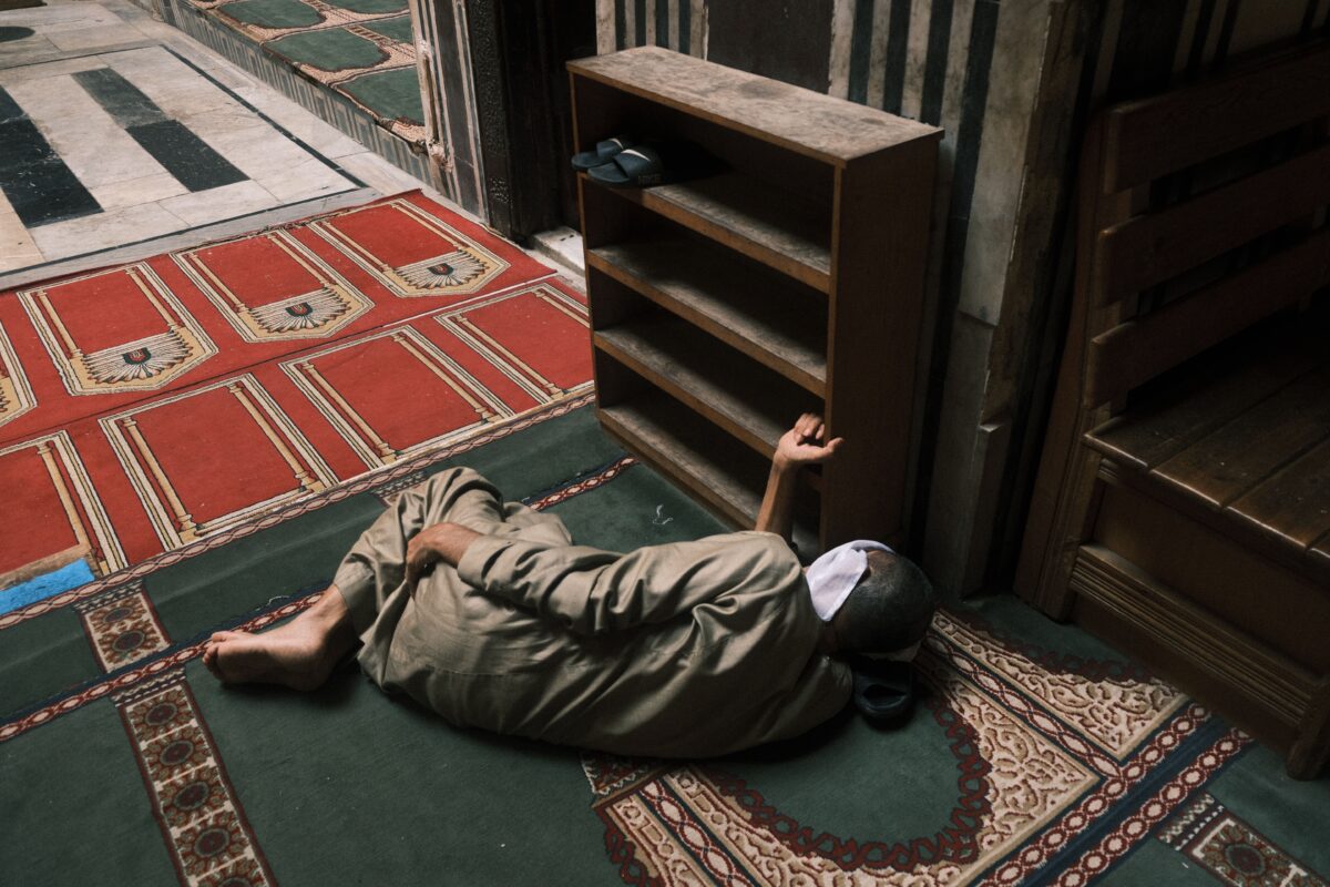 man-resting-inside-egyptian-mosque