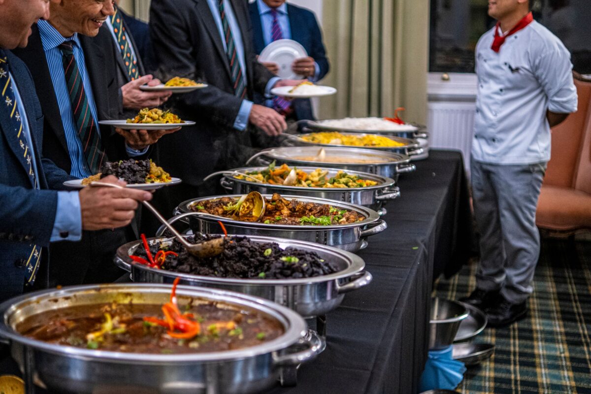 Blue Plate Isn’t Just Catering Events. It’s Redefining Hospitality in Chicago. 2 men-in-suits-choosing-food-from-table
