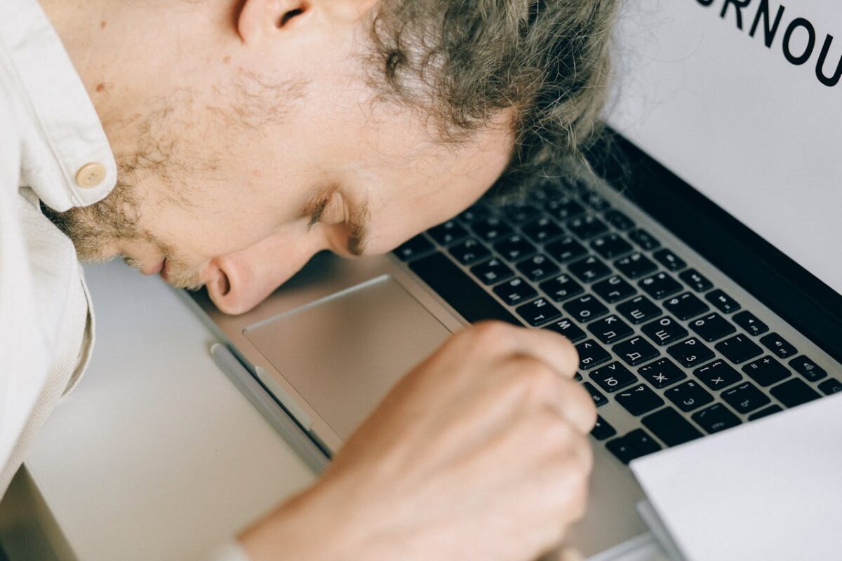overworked-employee-lying-in-front-of-laptop