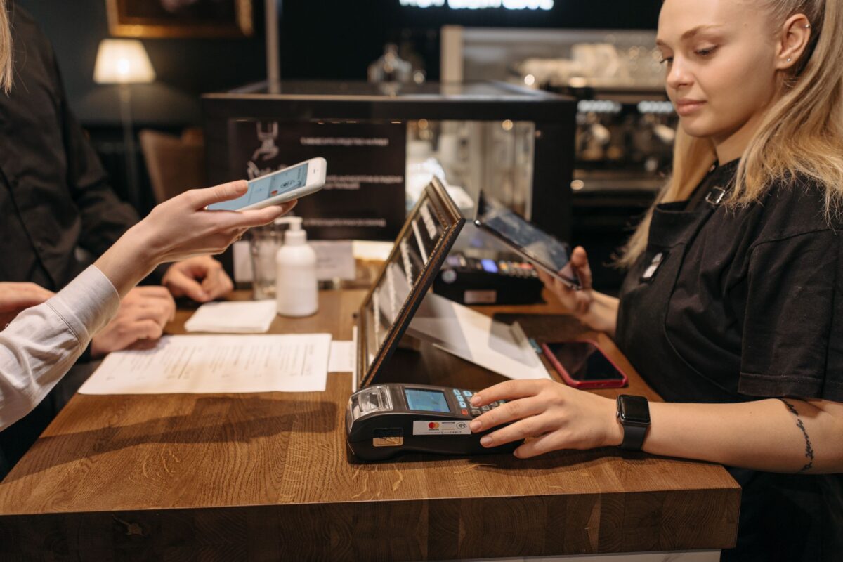 Hidden Fees Became America’s Second Price, And Shoppers Are Finally Pushing Back. 1 a-woman-in-black-shirt-using-a-payment-terminal-at-the-counter